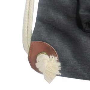 Close-up of brown leather reinforced corner patch and metal grommet with cotton rope knot