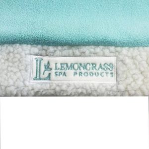 Close-up of embroidered Lemongrass Spa Products label on teal Santa hat