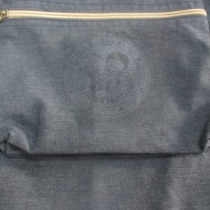 Gold zipper with brown leather pull and embossed logo detail on charcoal canvas pocket
