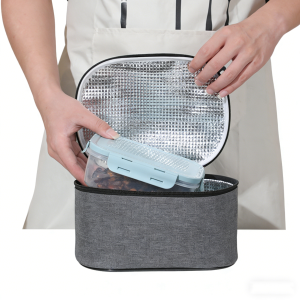 Grey lunch bag opening to show aluminum foil lining and lunch box inside