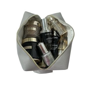 Large grey makeup pouch filled with skincare bottles showing inner capacity and lining