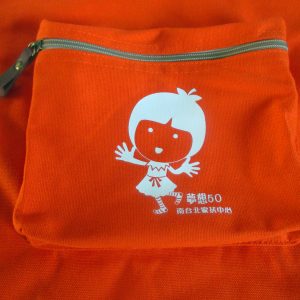 Orange canvas drawstring pouch with silver zipper and custom cartoon girl screen print