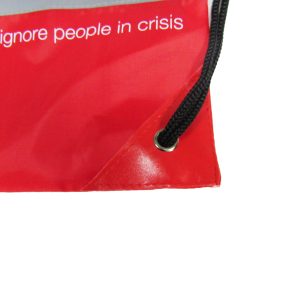 Corner grommet and black rope detail on red nylon drawstring bag
