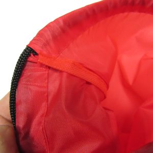 Interior red webbing and drawstring closure detail on safety bag