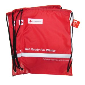 Red reflective drawstring bags stacked with British Red Cross logo
