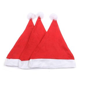 Three classic red nonwoven Christmas hats standing upright