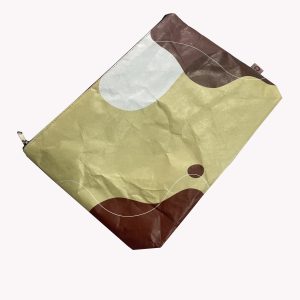 Angled view of beige Tyvek zip pouch with abstract geometric pattern