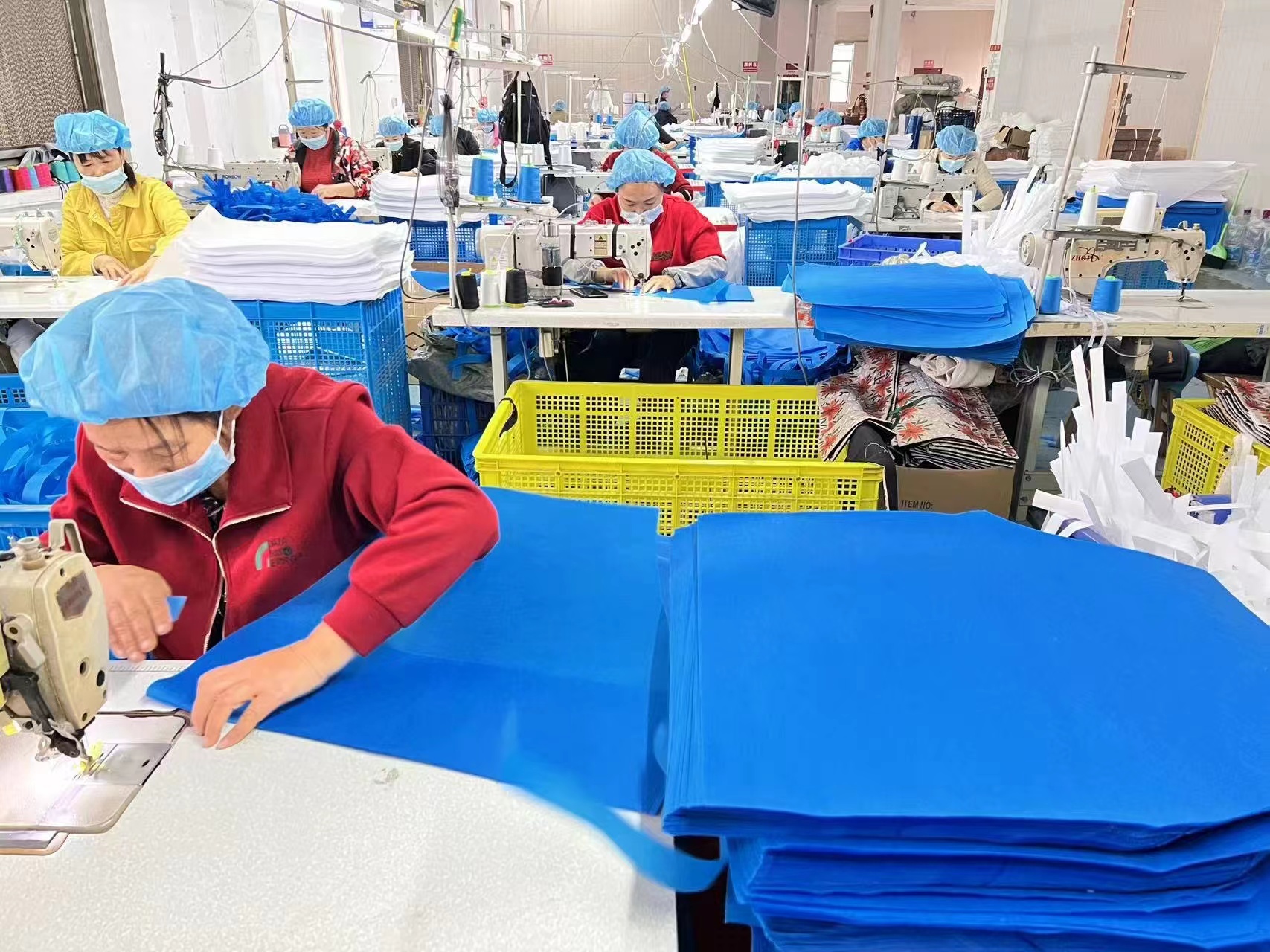 Bincai bag and pouch production line with workers sewing blue materials