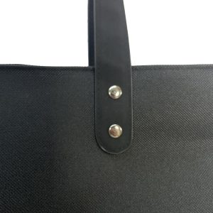 Black PU handle attached with silver metal rivets on black tote bag