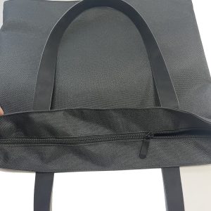 Top zipper closure detail on black and white spliced tote bag