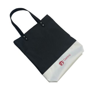 Angled view of black and white branded tote bag with PU handles