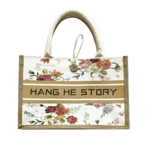 Canvas jute tote bag with wooden button and beige stripe reading HANG HE STORY