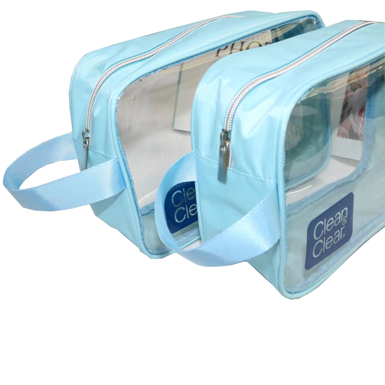 Stacked clear PVC toiletry bags with blue fabric trim and side handles