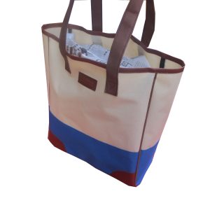 White and blue tote bag filled with papers showing large capacity side view