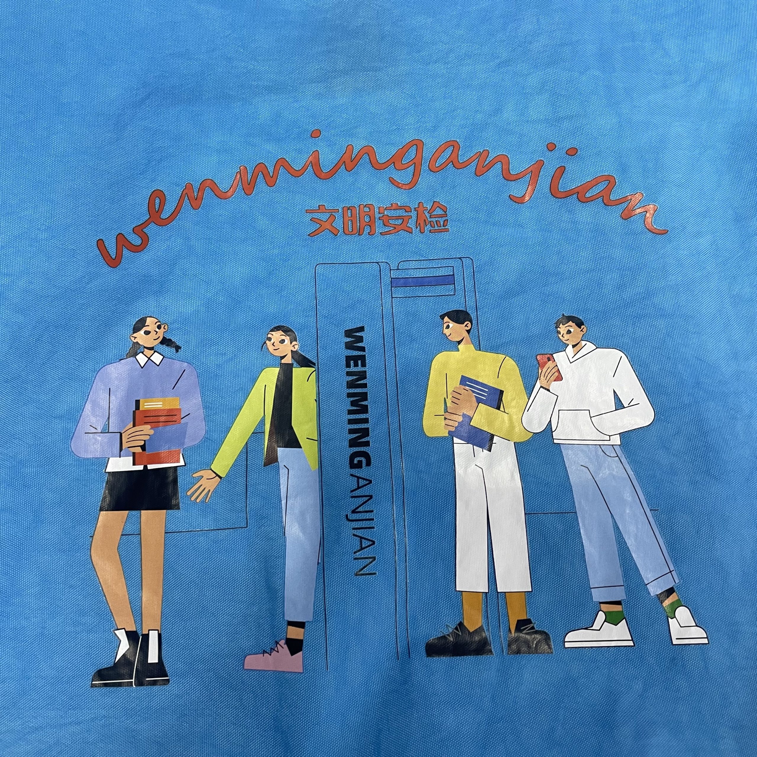 Close-up of custom fashion print graphic on blue tote bag