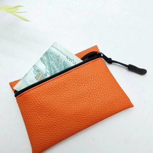 Orange pebbled PU leather coin purse with black zipper and paper money