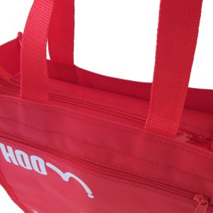 Close-up of red tote bag front zipper pocket and woven handle attachment