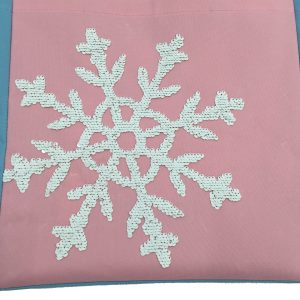 Detailed close-up of sequin embroidery snowflake pattern on pink bag