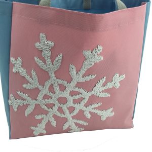 Close-up of white sequin snowflake embroidery on pink Oxford tote bag