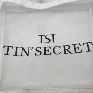 Close-up of black logo print on white mesh tote bag