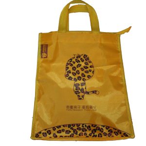 Yellow children's tote bag back view with cartoon leopard character and side label